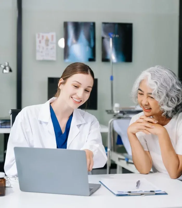 A Terrace Clinic doctor and a patient looking at a laptop together